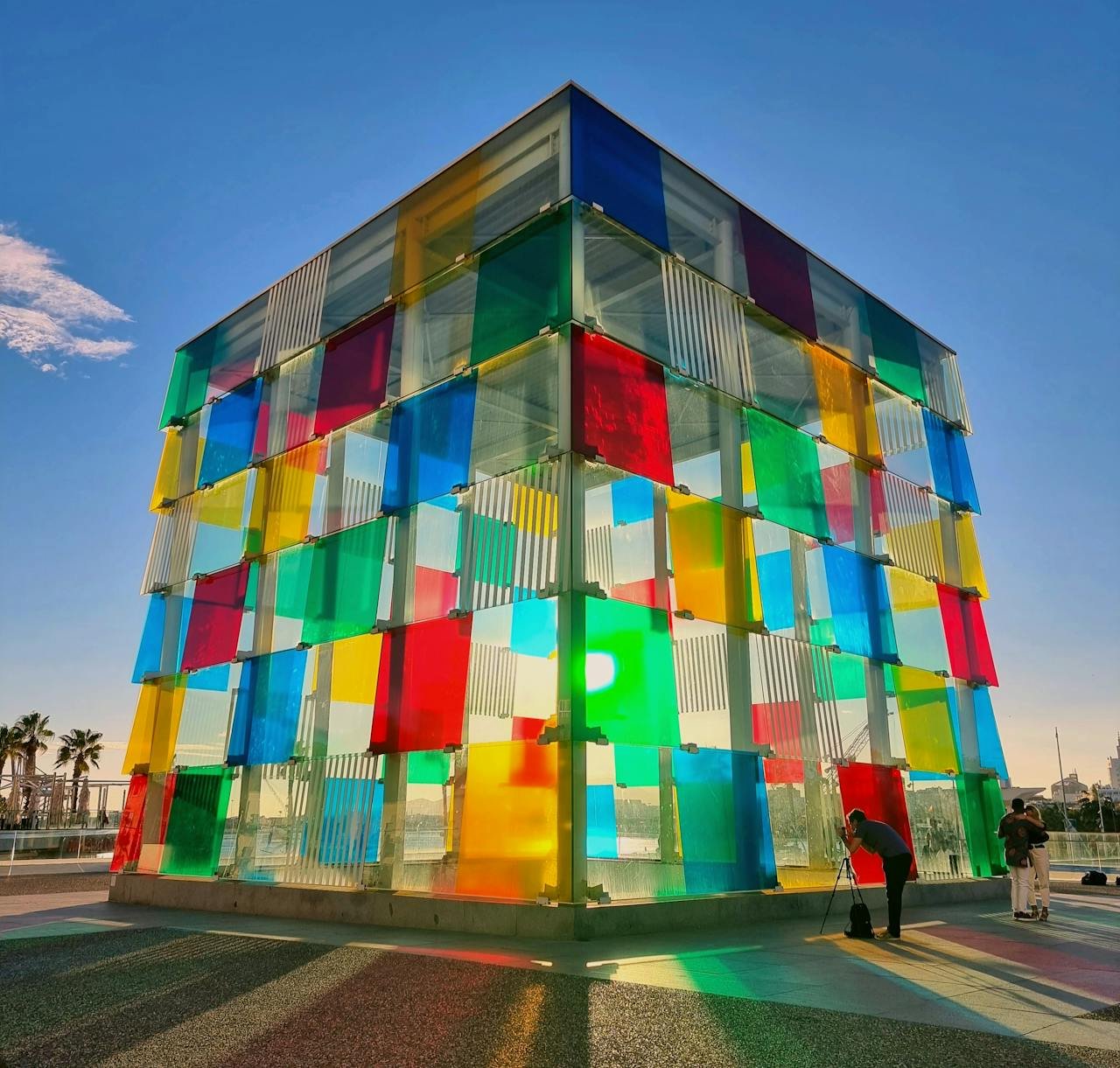 about-me Colorful glass cube reflecting sunlight in Málaga, Spain, showcasing modern art.